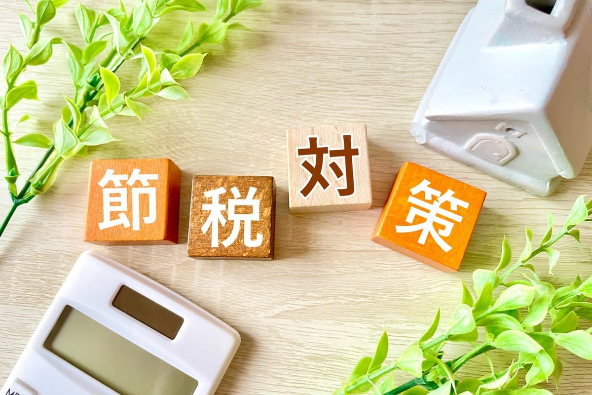 家の模型と電卓 (節税のイメージ)