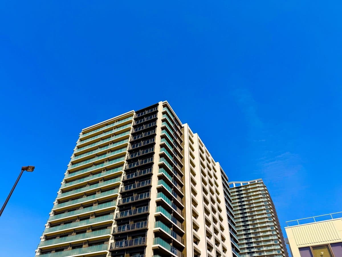 見上げたタワーマンション群と青空