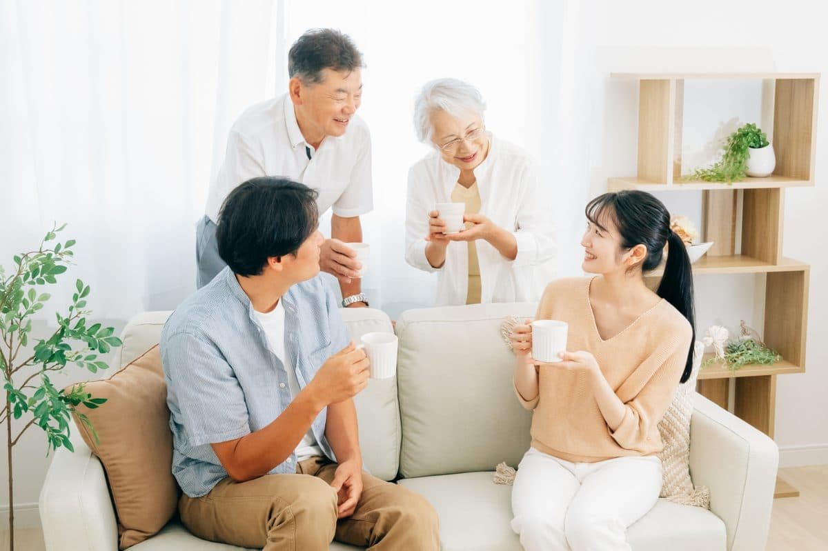 リビングで談笑する親世代と子世代の家族
