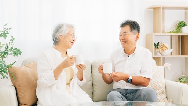 自宅のソファでお茶を飲むご夫婦
