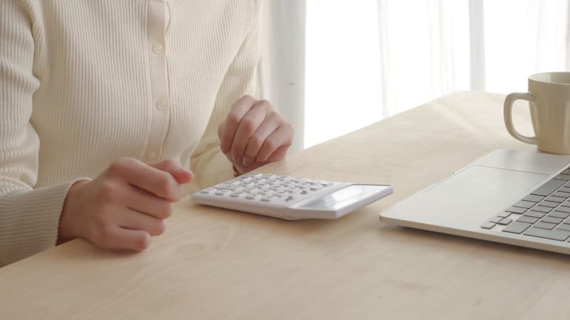 電卓を使って計算している手元